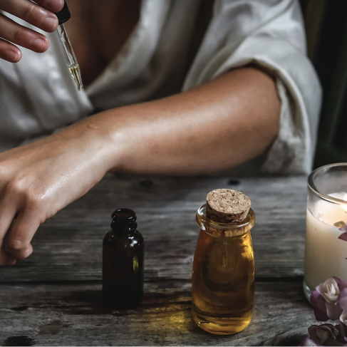 Photo d’une personne qui applique de l‘huile essentielle sur son bras pour représenter le reiki.