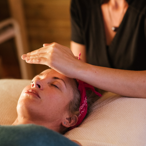 Photo d’une personne qui impose une mais sur la tête d’une autre pour représenter le reiki.